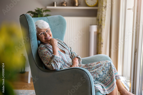 Schilderij op canvas Elderly woman sitting in an armchair in her home