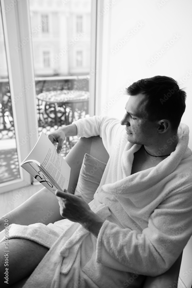 in the photo, a smug man in a bathrobe in hotels lying down enjoying the view from the window in the photo, a smug man in a bathrobe in hotels lying down enjoying the view from the window