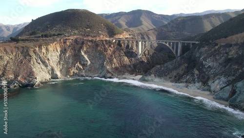 Aerial of the rugged coastline of Big Sur California. The Pacific Coast Highway and the famous Bixby Creek Bridge can be seen.