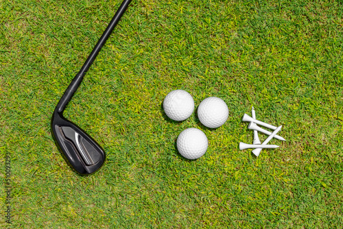 Flat lay with golf club, balls nad tees on green grass of golf course