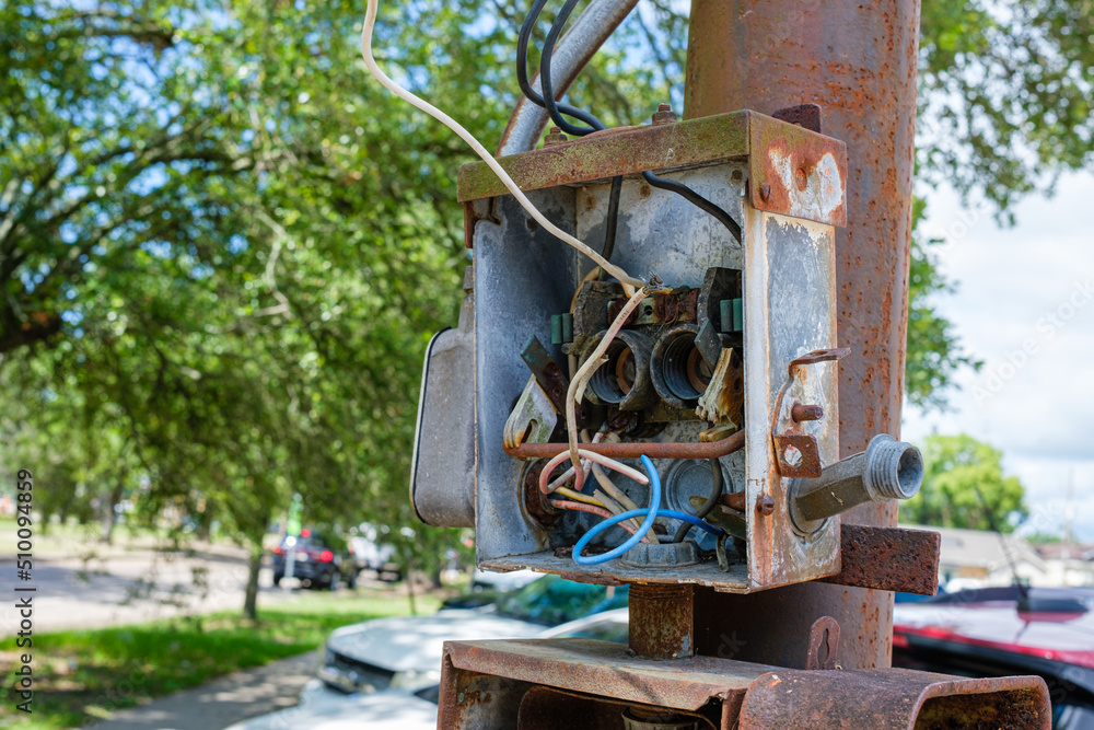 Abandoned, Exposed, and Rusted Outdoor Circuit Box on Rusted Metal Post on Street Corner in New Orleans, Louisiana, USA