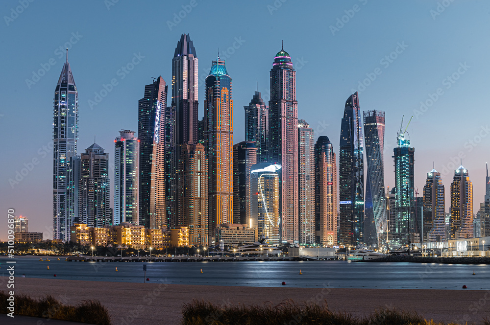 Modern glass skyscrapers in Dubai with blue sky in background. Impressive architecture of financial district and Dubai marina. 