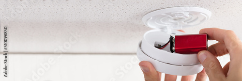 Konstfotografi Person's Hand Inserting Battery In Smoke Detector