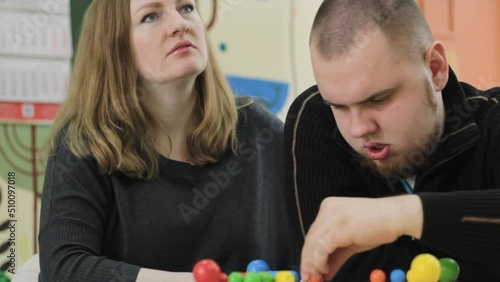 A female psychologist works with an adult boy with autism in the office. The concept of autism