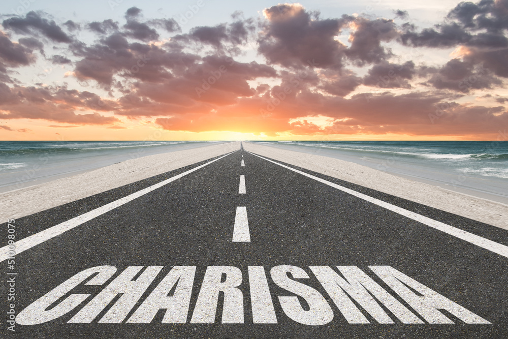 The word Charisma written on a highway at the beach at sunset.