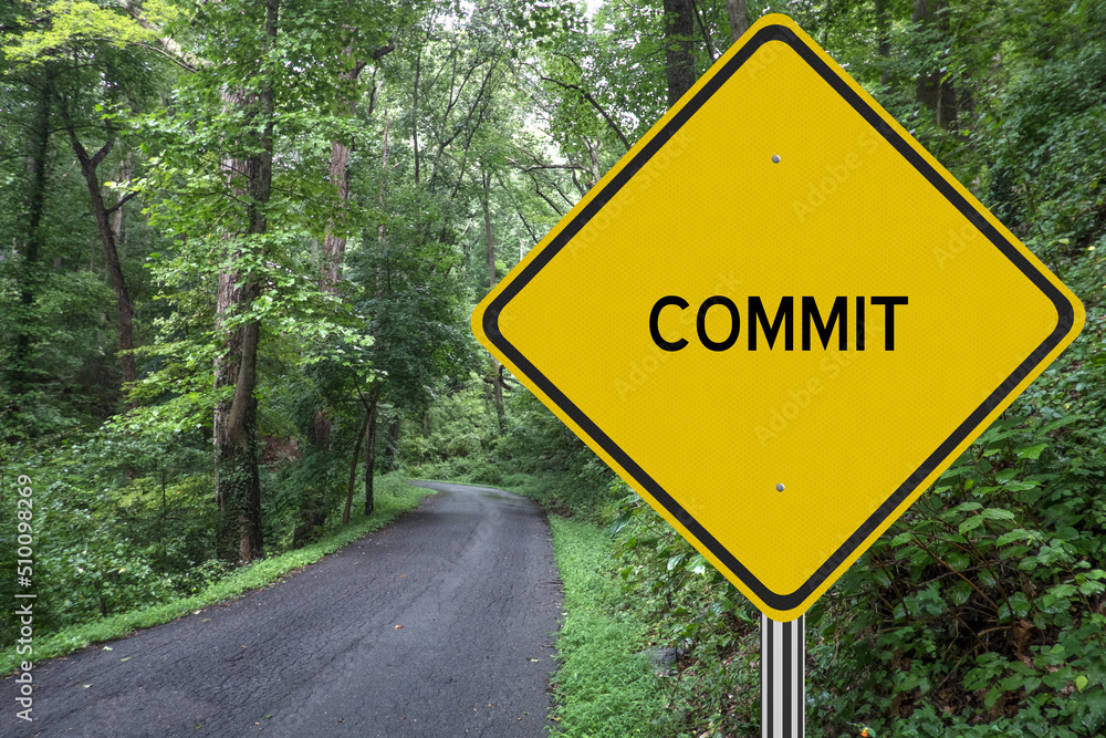 The word Commit written on a sign for commitment and dedication concept.
