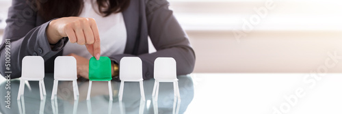 Tableau sur toile Businesswoman Choosing Green Chair Among White Chairs In A Row