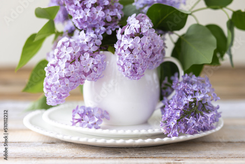 Beautiful spring composition with lilac flowers in a white cup for countryside decor