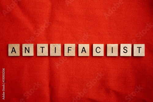 ANTIFA concept with wooden tile letters on a red background.