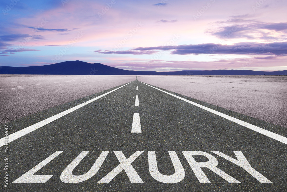 Naklejka premium The word Luxury on a highway leading to a beautiful background.
