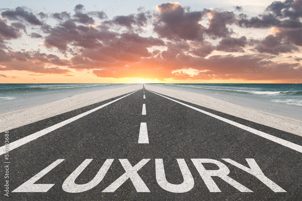 Fototapeta premium The word Luxury on a highway leading to a beautiful background.