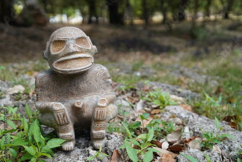 Obraz na płótnie Taino Antique Stone Idol God Figure standing over rocks with grass near by, close up