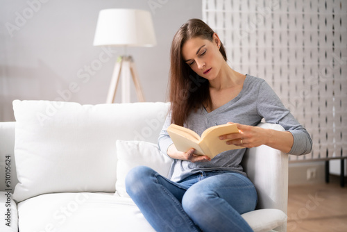 Adult Person Sitting On Sofa Reading Book