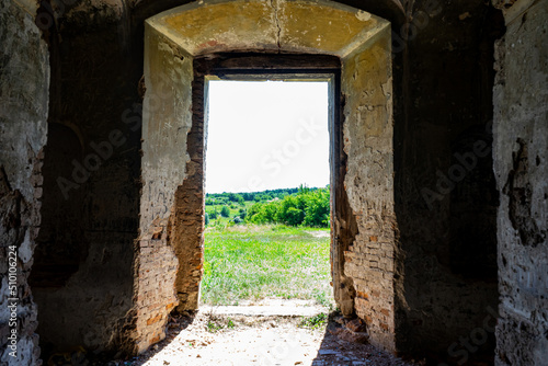 Exit from the old ruined building with thick walls. View from the exit of the castle on the picturesque landscape