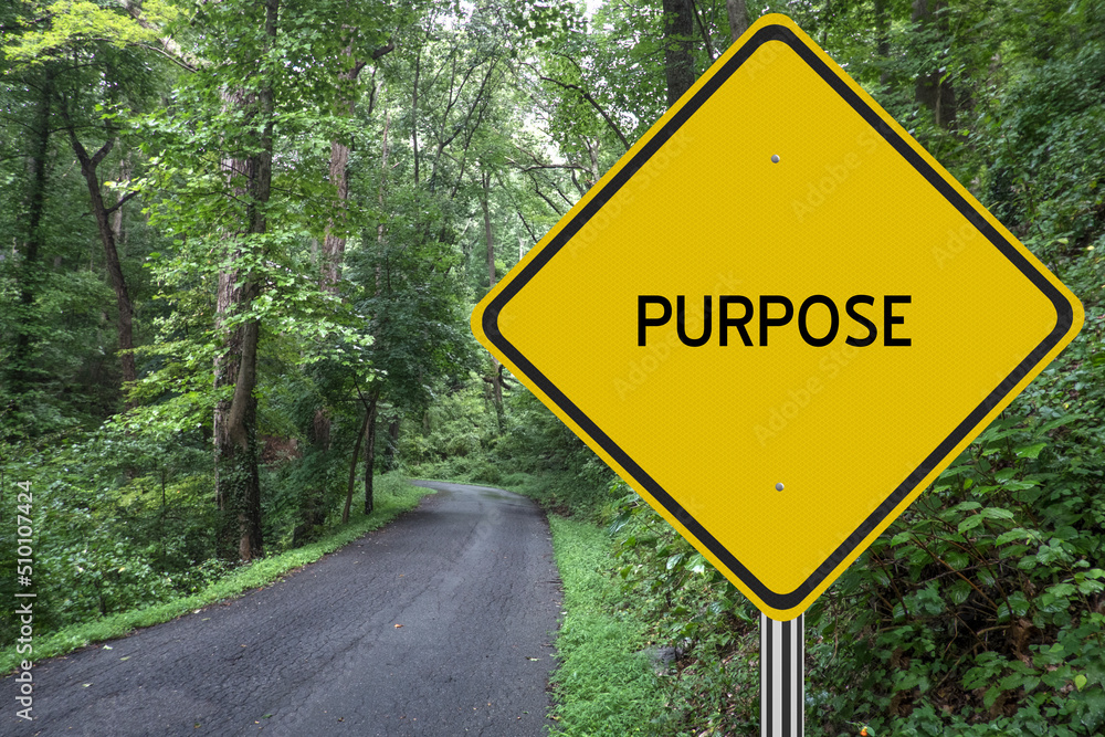 Inspirational Purpose sign with path leading into the woods.