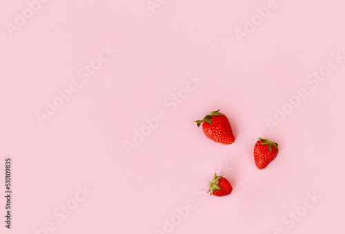 Fresh red strawberry on pink background, top view. Minimalistic scattered berries pattern. Creative food concept. Flat lay, copy space, top view