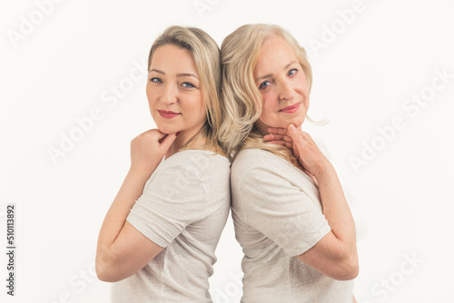 two blonde European women standing back to back medium closeup white background studio shot feminine concept. High quality photo