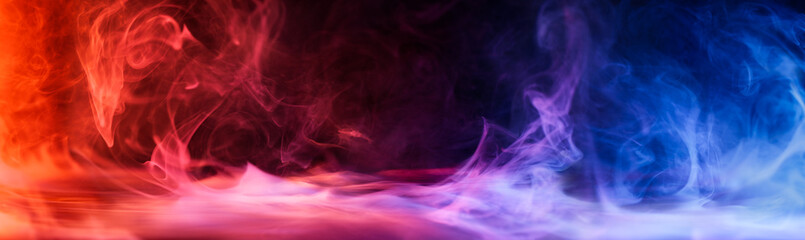 Dramatic smoke and fog in contrasting vivid red, blue, and purple colors. Vivid and intense abstract background or wallpaper.