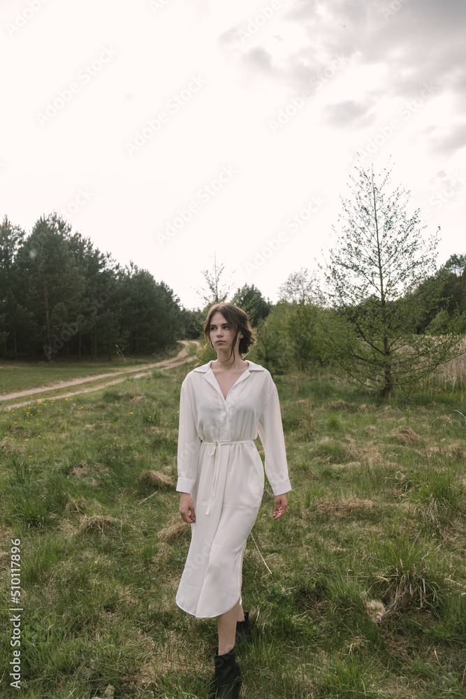 beautiful girl with her hair gathered in a free bun, dressed in a white long light dress beautiful girl with her hair gathered in a free bun, dressed in a white long light dress