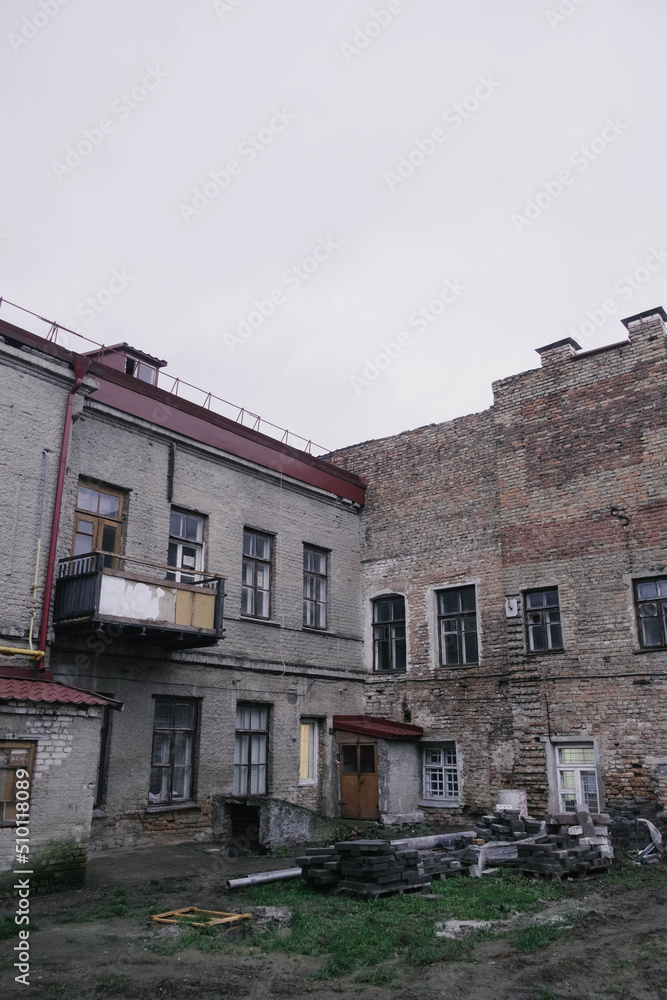 photo of the old district in the city, with brick walls and piles of building material in cloudy autumn weather