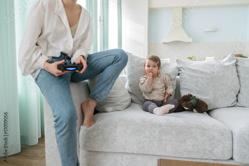 Little daughter watches mom play prefix in a bright apartment