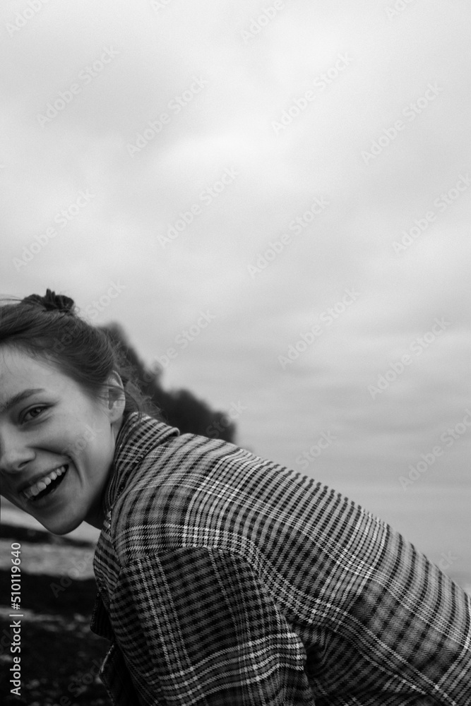 Black and white portrait of a hesitant girl against the background of the cold sea Black and white portrait of a hesitant girl against the background of the cold sea