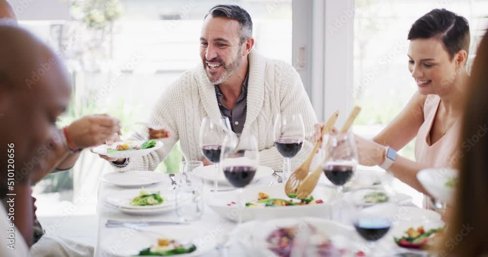 Diverse group of cheerful best friends eating feast and drinking wine while having lunch party around a table in a restaurant or home. Happy men and women socialising with each other over a meal Diverse group of cheerful best friends eating feast and drinking wine while having lunch party around a table in a restaurant or home. Happy men and women socialising with each other over a meal