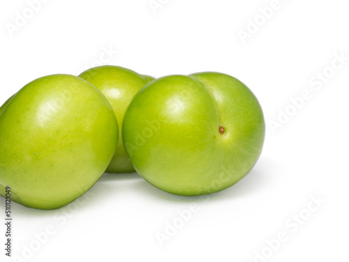 Green cherry plum on a white background. Fruit for making tkemali sauce. Useful fruit.