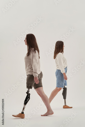 Handicapped women walking against gray background photo
