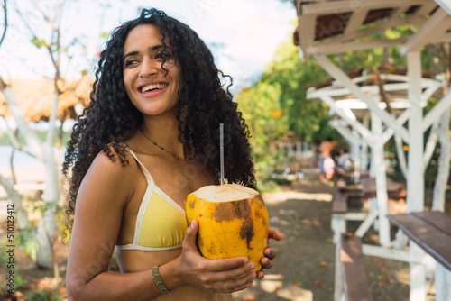 Woman drinking a coconut photo