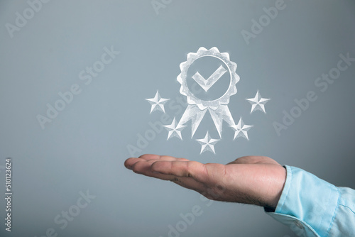 The symbol of the guarantor of quality and five stars from the network. Man holding in his hand