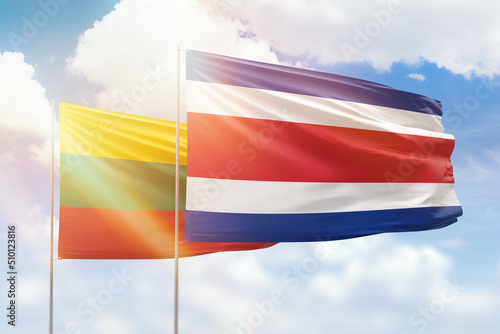 Sunny blue sky and flags of costa rica and lithuania