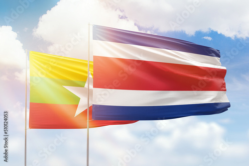 Sunny blue sky and flags of costa rica and myanmar