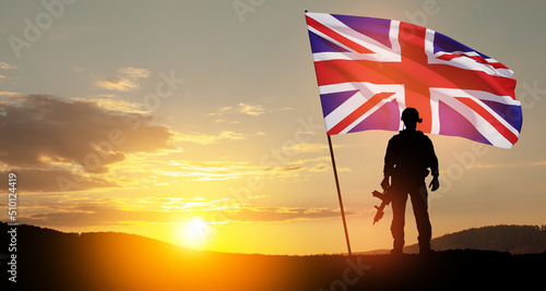 Canvas Print Silhouette of soldier with United Kingdom flag on background of sunset
