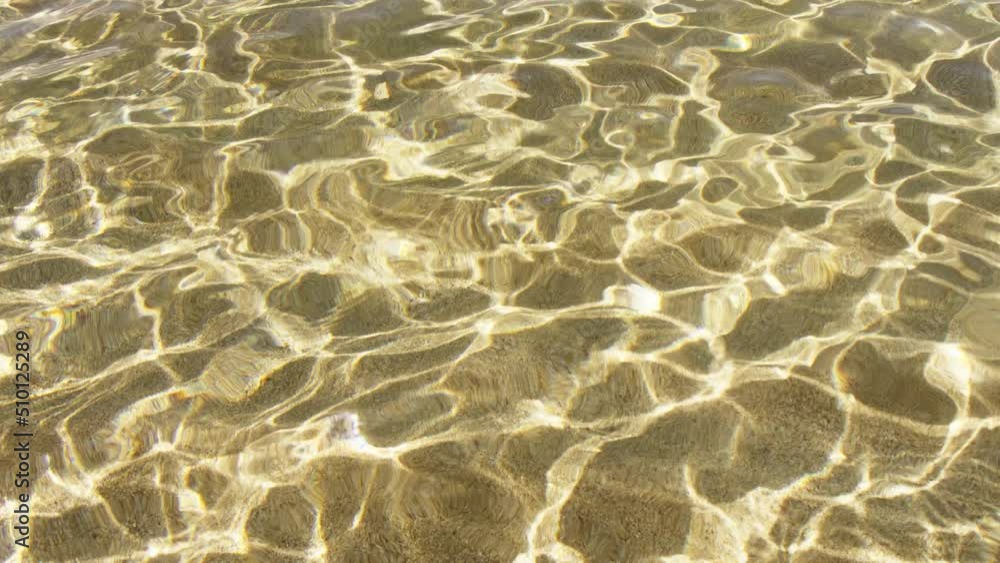 Top down closeup view of pure transparent sea water texture. Slow motion of sun rays reflecting from clear water surface. Background of water surface with copy space for commercial footage RED camera Top down closeup view of pure transparent sea water texture. Slow motion of sun rays reflecting from clear water surface. Background of water surface with copy space for commercial footage RED camera