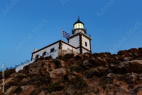 The old lighthouse on the rocky cliff at night.