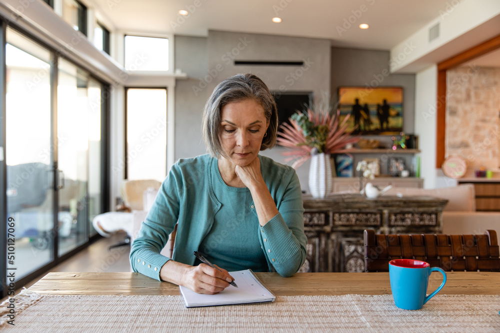 Focused Woman Writes In Her Notebook Focused Woman Writes In Her Notebook