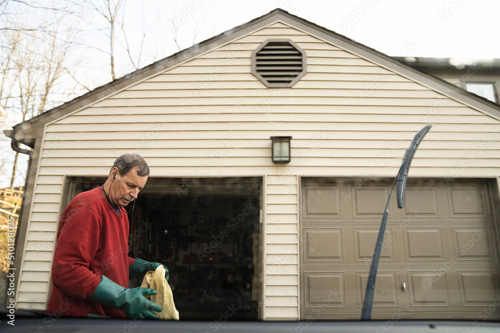 Older man washes his car at home Older man washes his car at home