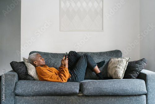 African American lady browsing phone in living room photo