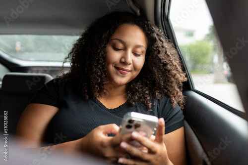 Young Woman Smiles At Phone While In The Car photo