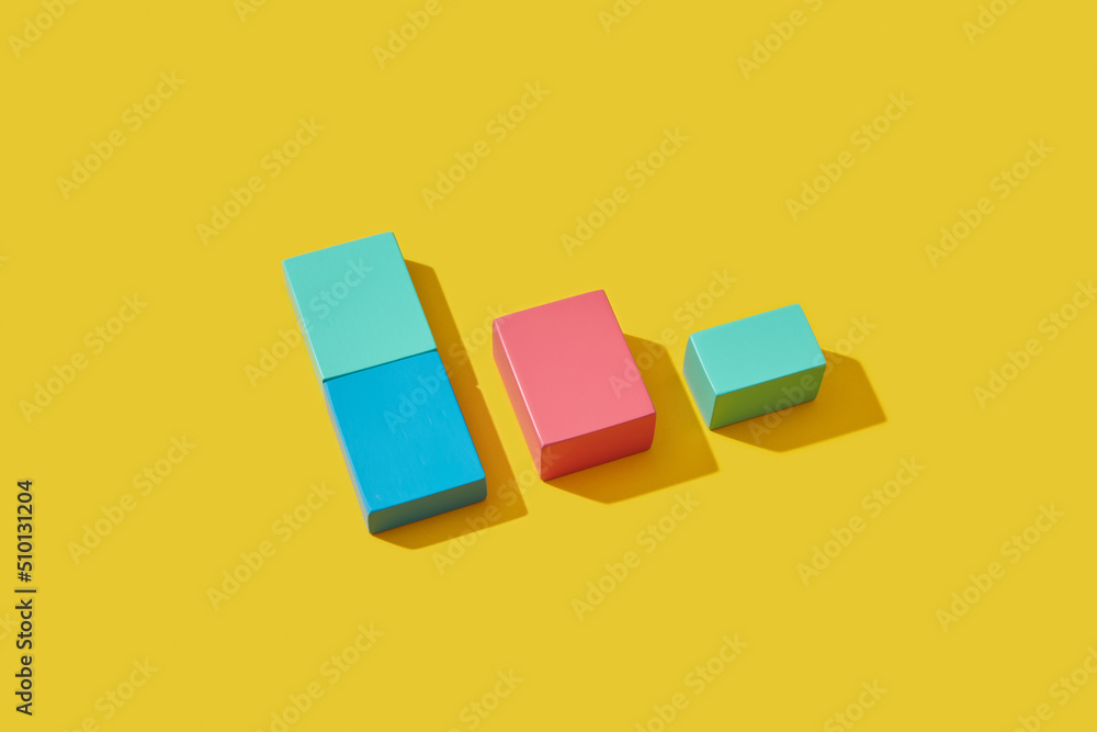 Colored wooden toy cubes lying on yellow background Colored wooden toy cubes lying on yellow background