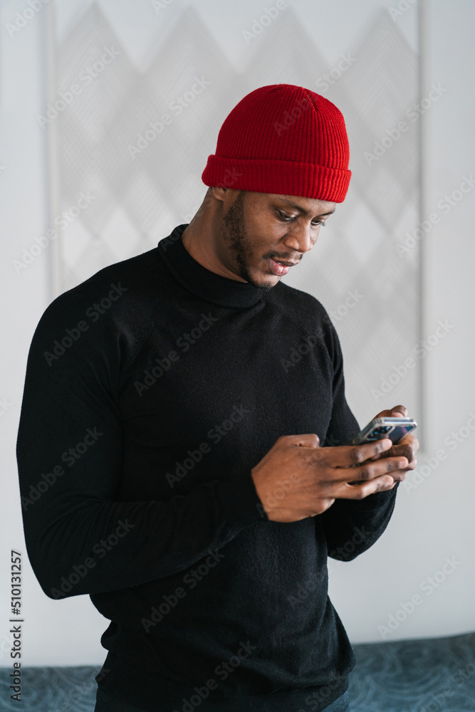 Trendy black man using smartphone at home Trendy black man using smartphone at home