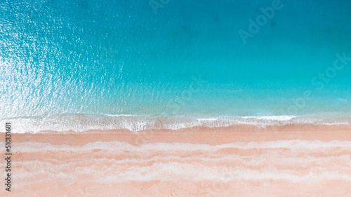 aerial photo of a sandy beach with azure water