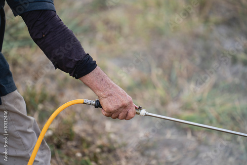 Hand of a man with a hand sprayer in his hand photo