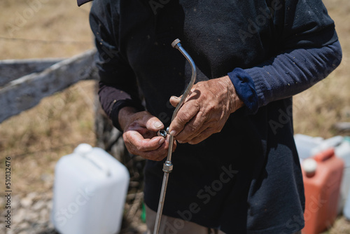 Hands of a man repairing a sprayer of a fumigation pump.  photo