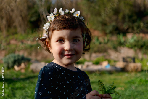 Little girl spring portrait with flowers crown on head photo