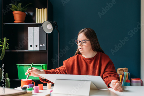 Girl with Down Syndrome Painting at Home photo