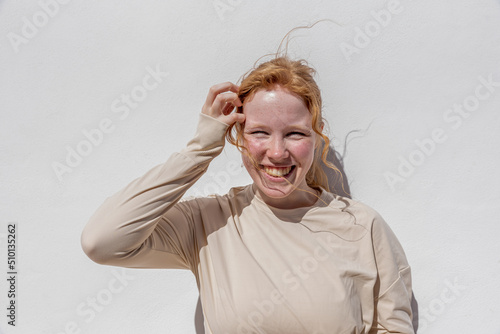 Joyful lady with ginger hair smiling in sunlight photo
