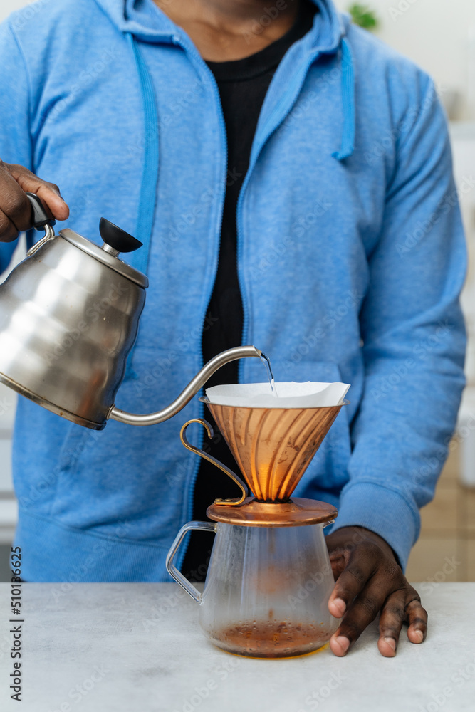 Young black man brewing filter coffee in a kitchen Stock Photo Adobe