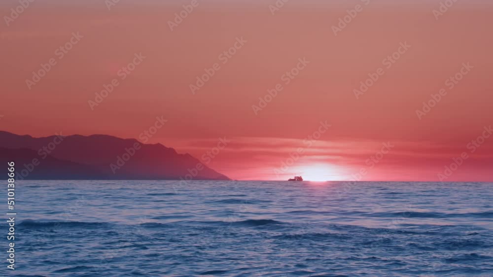 A fishing boat is turning home at sunset in Kuşadası Bay, Aydın province, Turkey. A fishing boat is turning home at sunset in Kuşadası Bay, Aydın province, Turkey.
